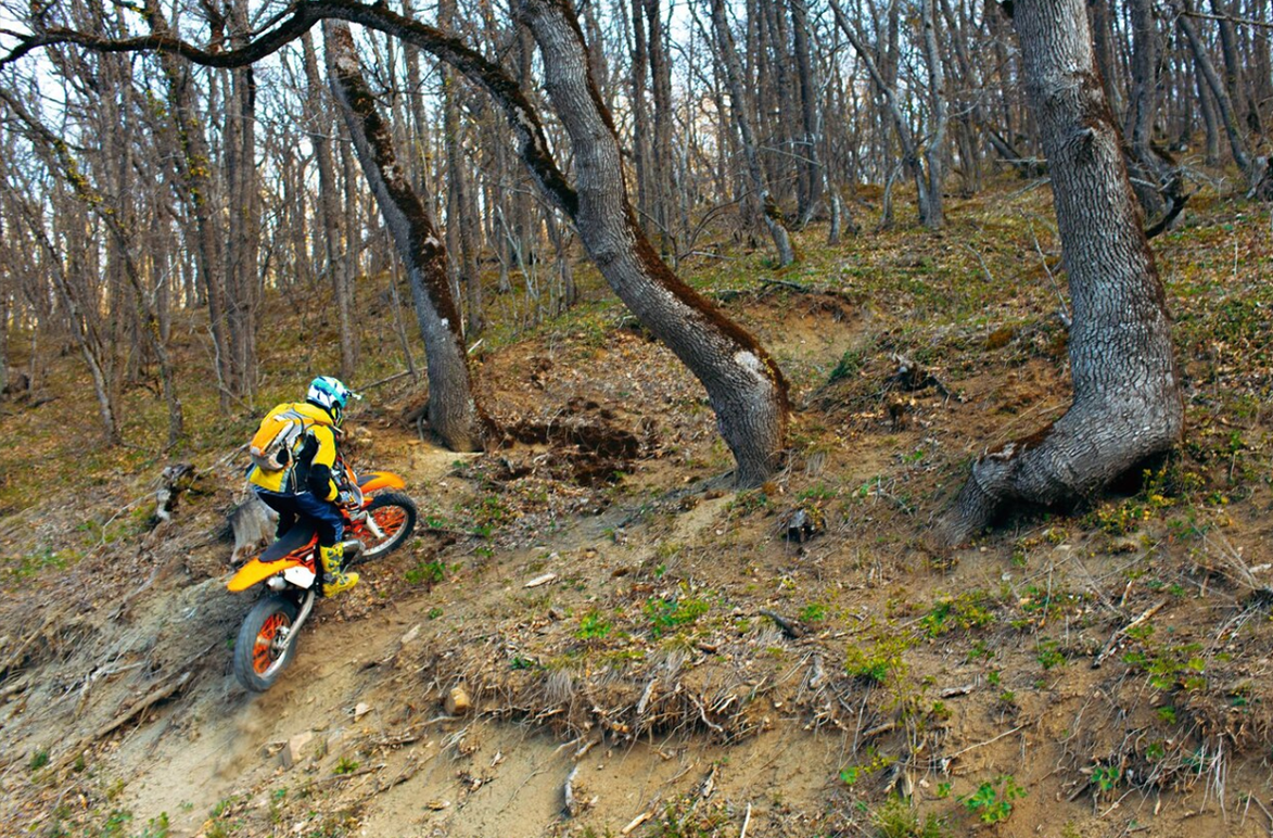 A dirt bike on a rugged trail, kicking up dust